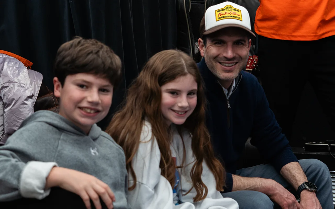 Two children and their dad smiling on The Fun Tour bus