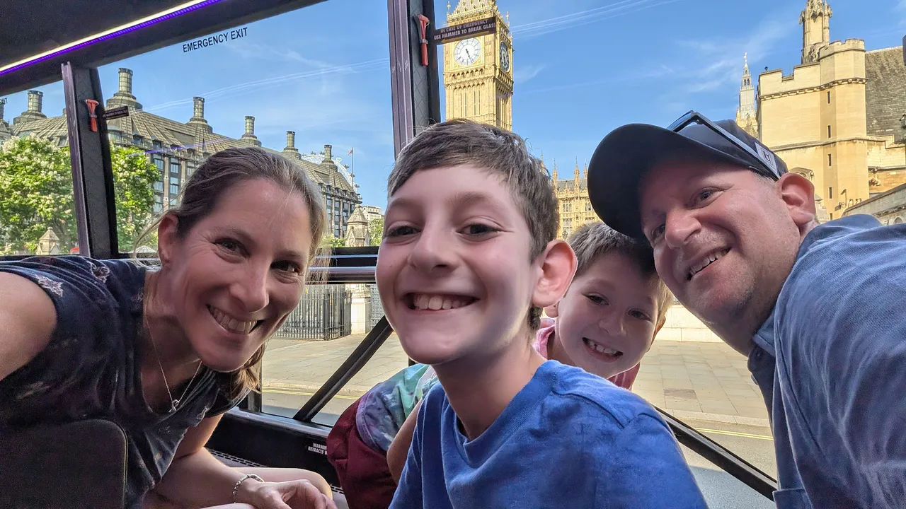 A family taking a selfie on the bus, with Big Ben through the window